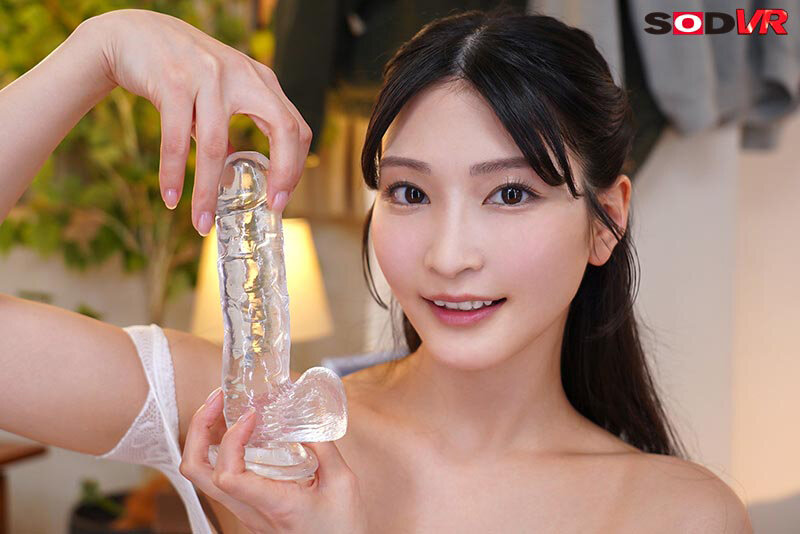 白いランジェリー姿の本庄鈴が透明なアダルトグッズを手に持ち微笑むオナサポシーンのサンプル画像