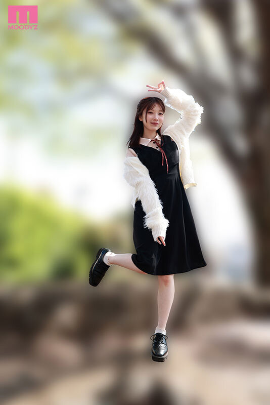 白いファー風カーディガンと黒いワンピース姿の石川澪が、片脚を上げてポーズを取る全身カット