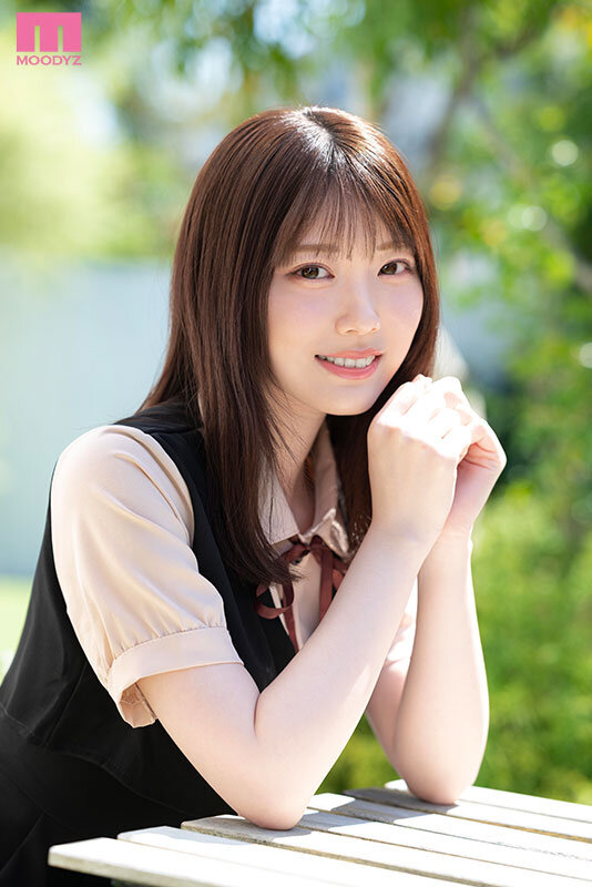 黒いワンピース風コーデの石川澪が屋外のベンチで両手を添えて微笑む、顔寄りのカット