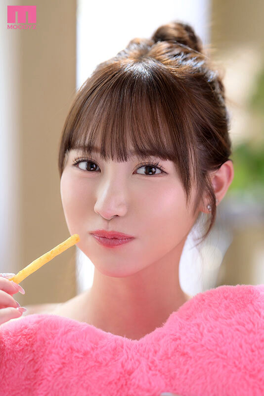 お団子ヘアの女性がピンクのふわふわした服を着て、ポテトを口元に近づけてこちらを見ている