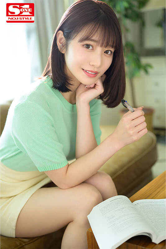緑のニットと白いショートパンツ姿の河北彩花が、教材とペンを手に微笑む家庭教師シーン